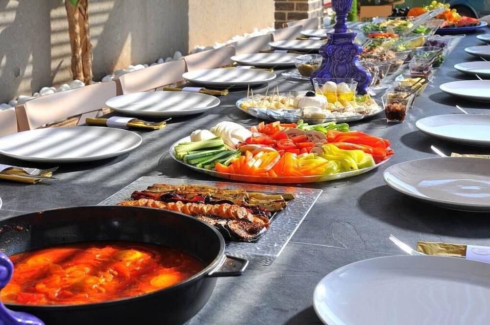 השולחן הארוך ערוך לארוחה עם מגשי סלטים ומנות